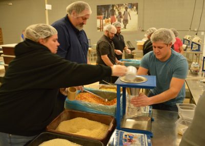 Crawford Roofing Employees volunteering with Feed My Starving Children Through Rabine Group Foundation