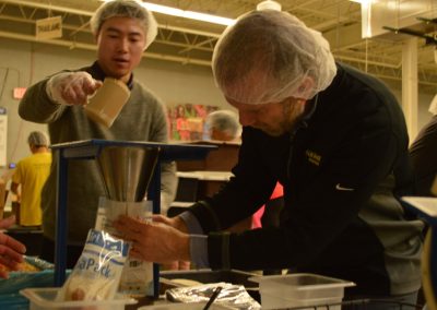 Crawford Roofing Employees volunteering with Feed My Starving Children Through Rabine Group Foundation